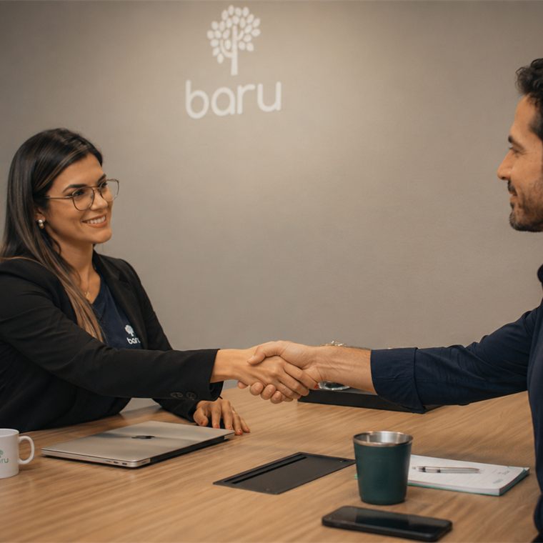 Especialista da Baru Financeira apertando a mão de um cliente na sala de reunião