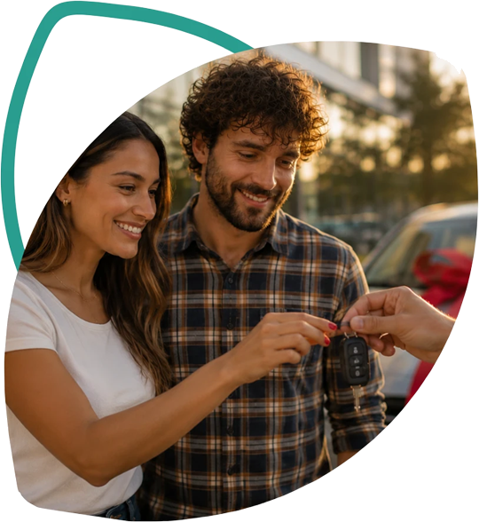 Casal recebendo a chave do carro novo, com laço vermelho no veículo