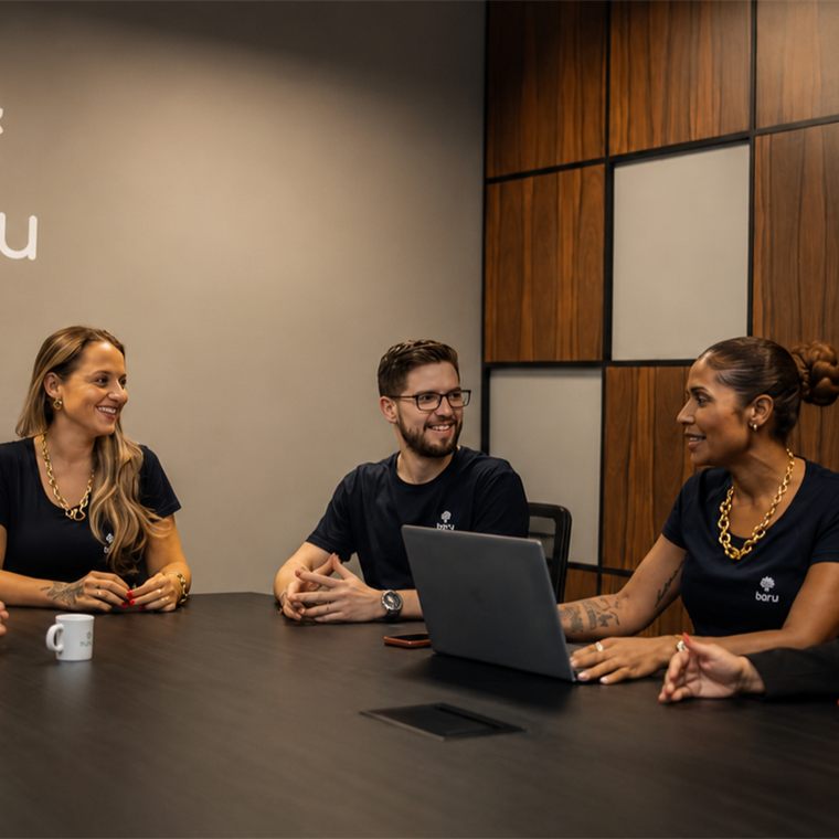 Equipe da Baru Financeira reunida em sala de reunião com a marca Baru