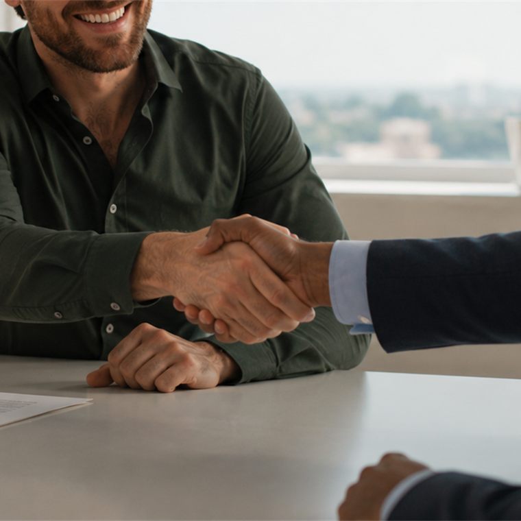 Aperto de mãos entre especialista e cliente fechando uma negociação