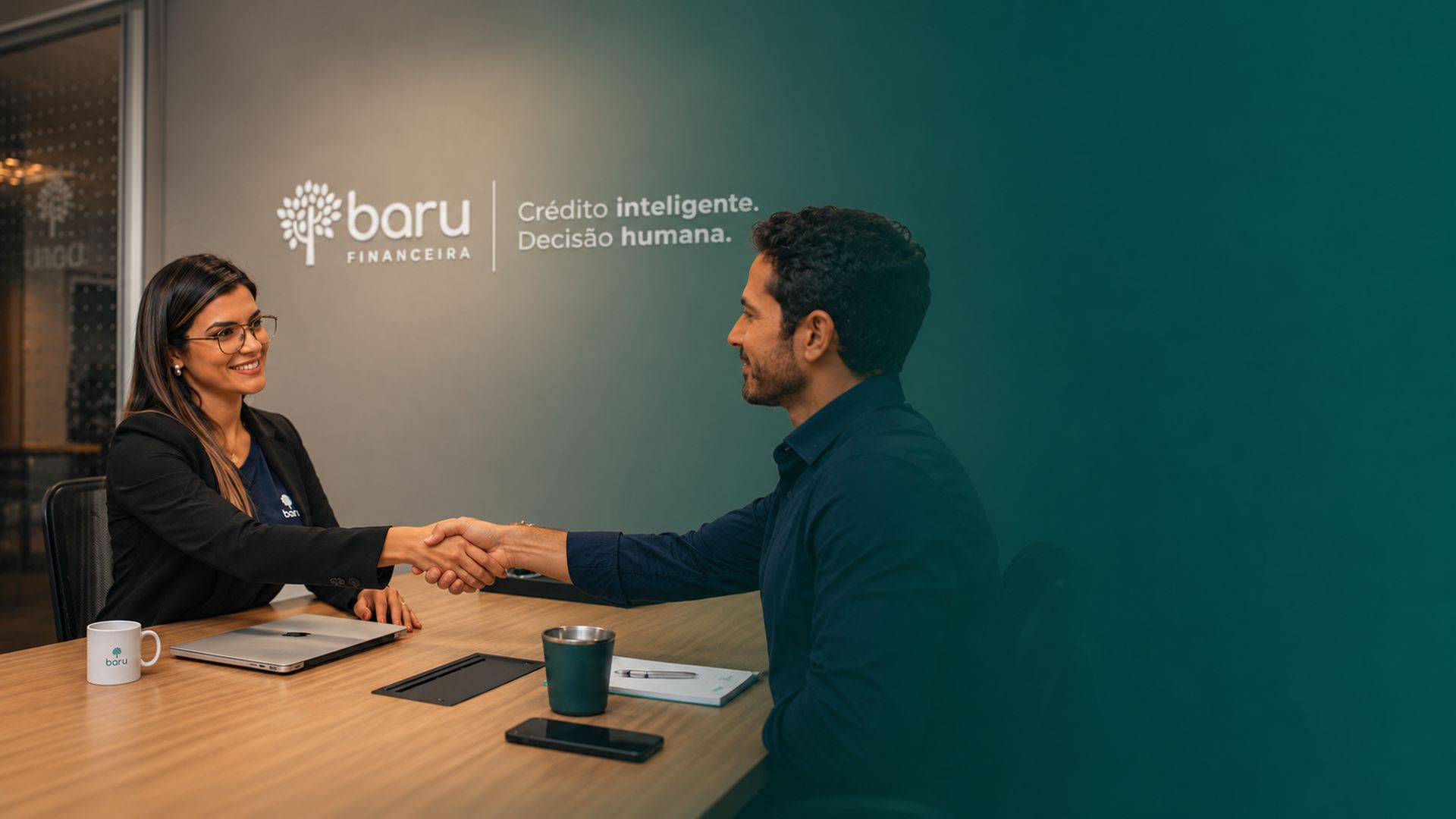 Especialista da Baru Financeira cumprimenta um cliente em sala de reunião, com a marca Baru e a frase Crédito inteligente. Decisão humana. na parede